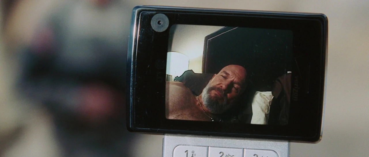 A shirtless Obadiah Stane calling Tony on a flip phone